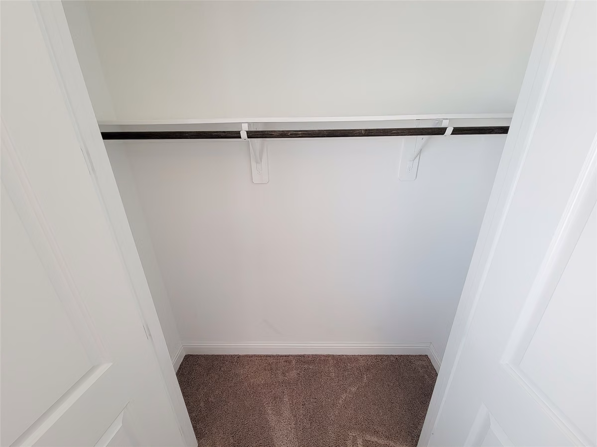 Spacious closet with a single hanging rod, perfect for organizing your wardrobe.