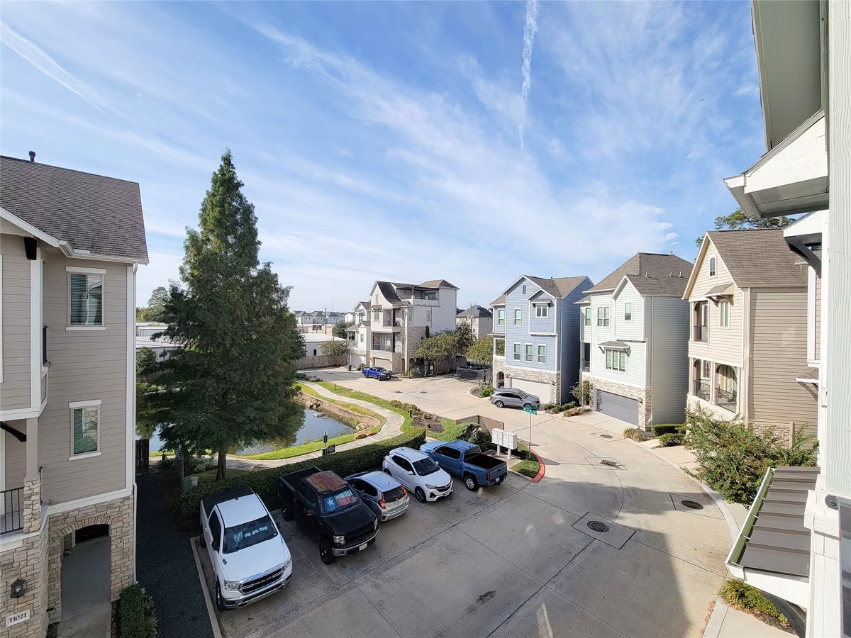 Charming neighborhood with modern three story homes, a serene pond, and ample parking, offering a peaceful and convenient living environment.