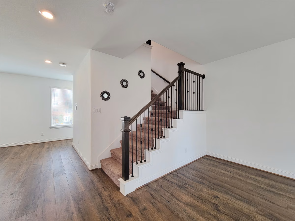 Elegant staircase with dark wood accents leads to the upper level.