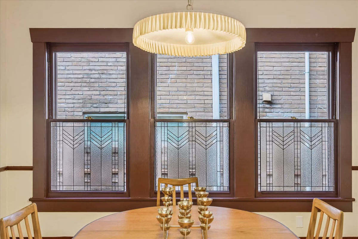 The formal dining room features wood stained trim & chair rail, as well as custom stained glass windows & updated lighting.