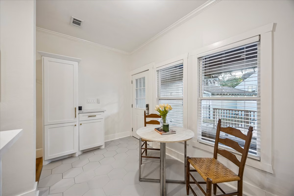 The breakfast area with a view to the back door. Thoughtfully placed cabinets serve as the perfect "Landing zone" for all the things after a long work day.