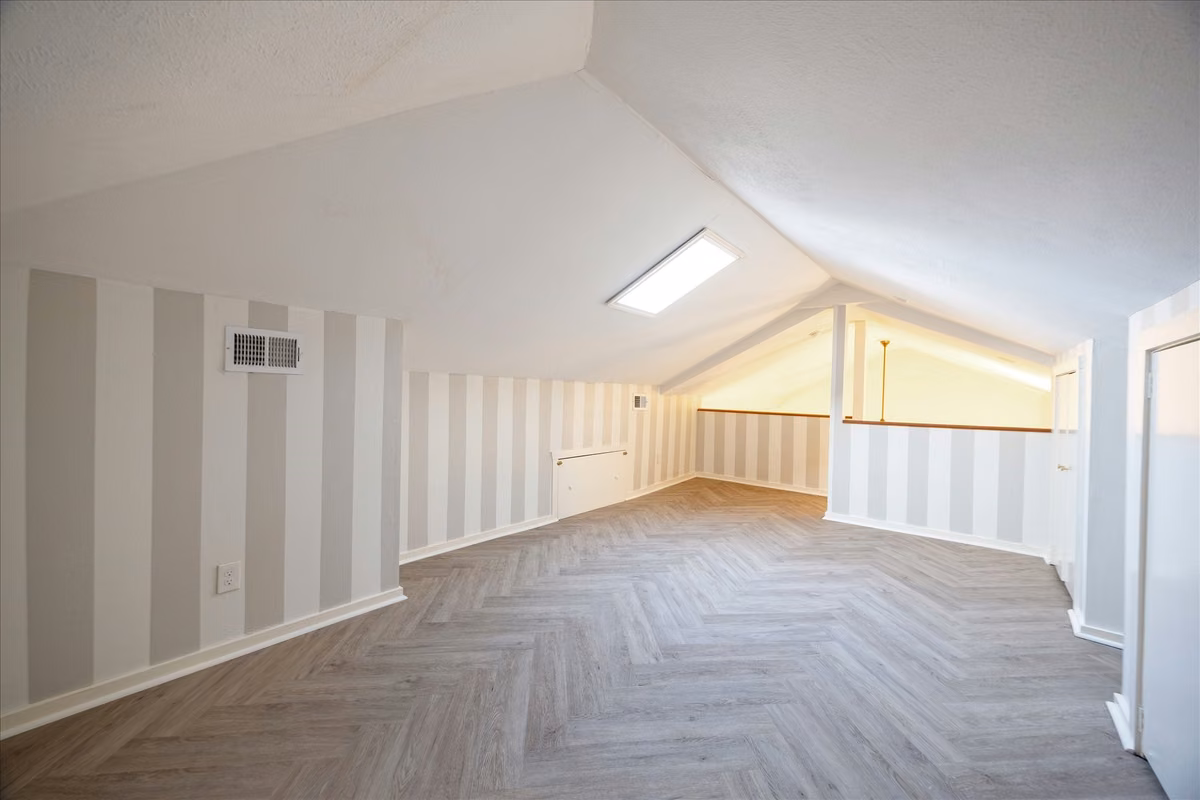 The loft space presents abundant options as a home office, media room, or yoga studio.