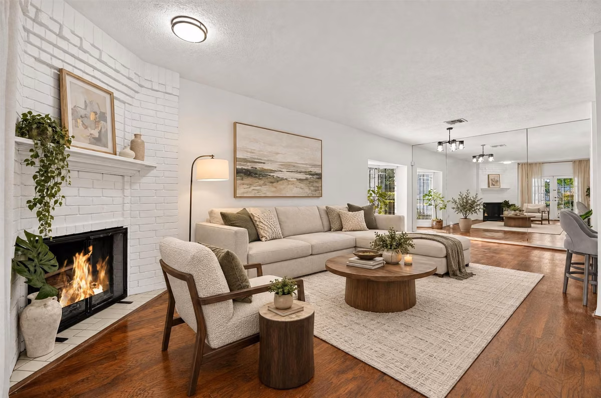 Bright living room with a fireplace and an open layout connecting to the dining area. Virtually staged.