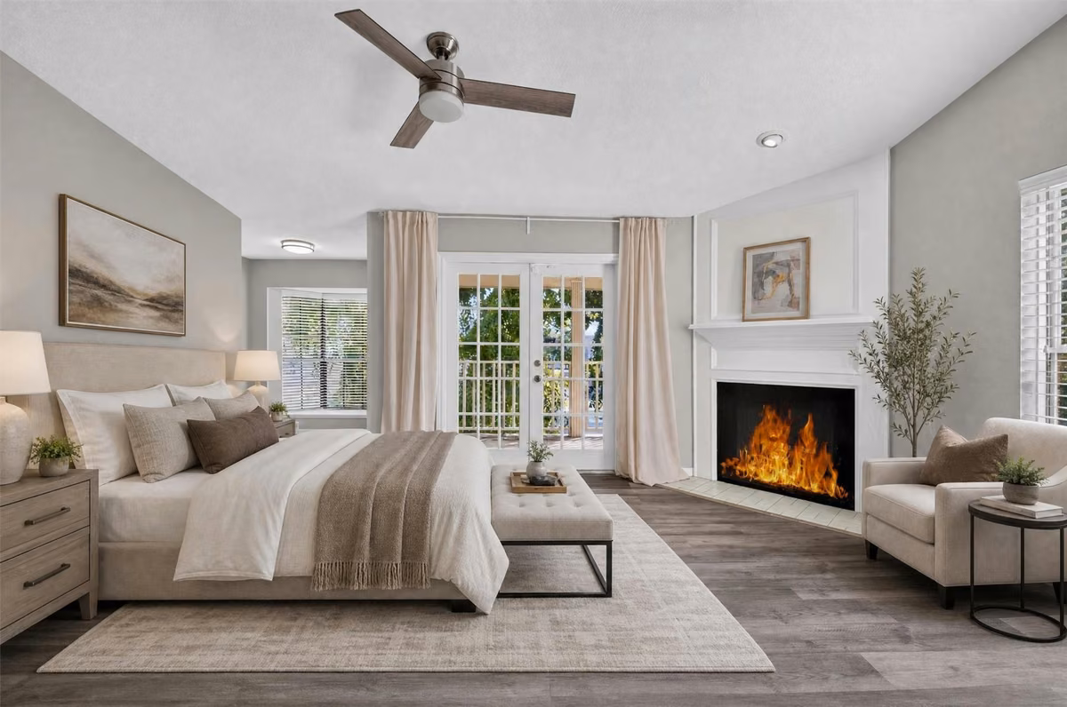 Spacious primary suite featuring a fireplace and French doors opening to a private covered balcony. Virtually staged.