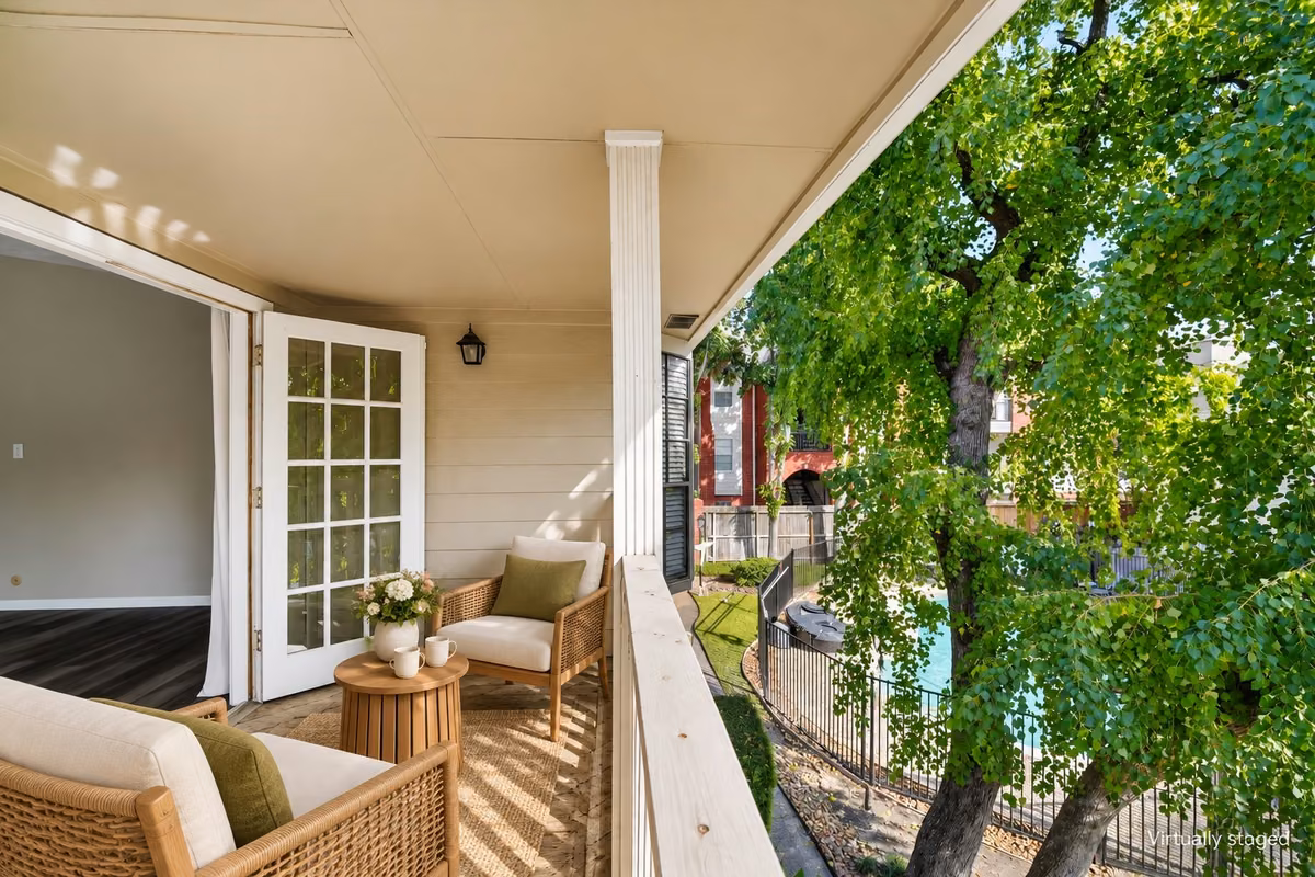 Covered balcony off the primary suite, overlooking mature trees and the community pool—a relaxing retreat for morning coffee or unwinding outdoors. Virtually staged.