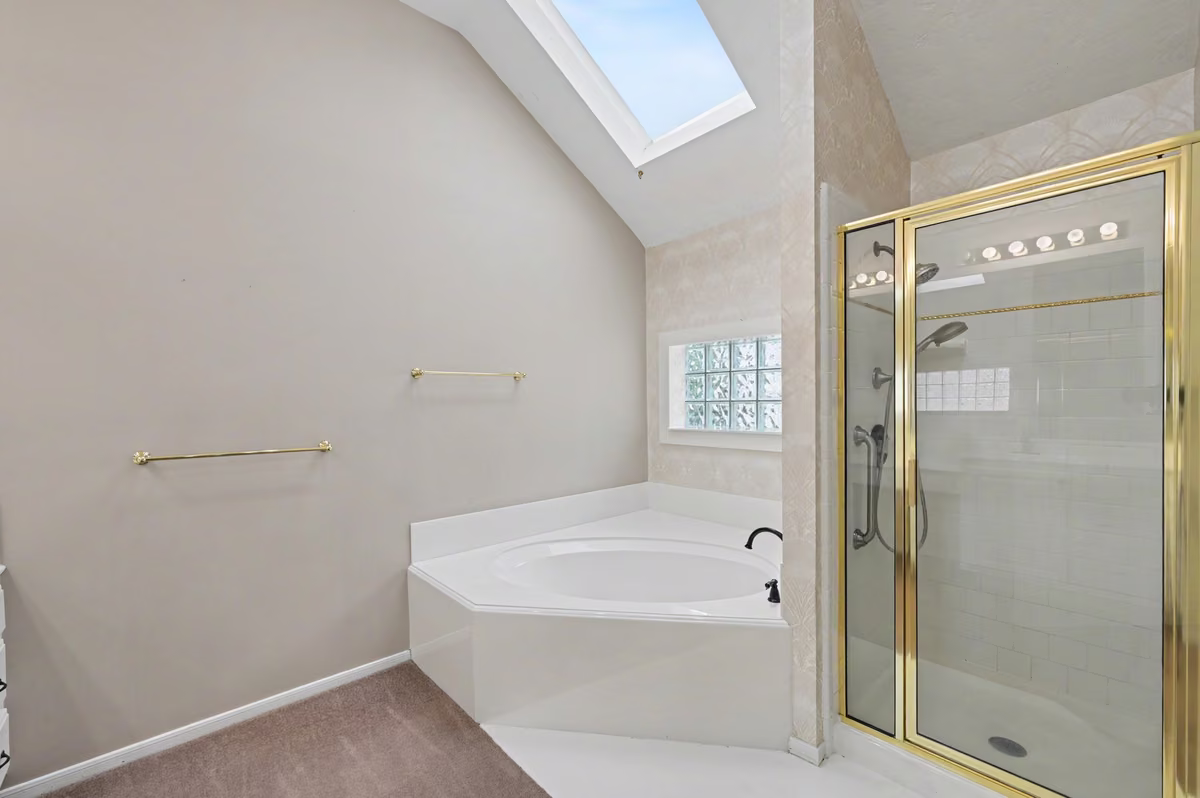 Primary En-Suite soaking tub, stand-alone shower, and skylight for natural light.